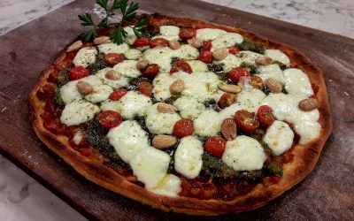 Pizza de tomate, queso y pesto